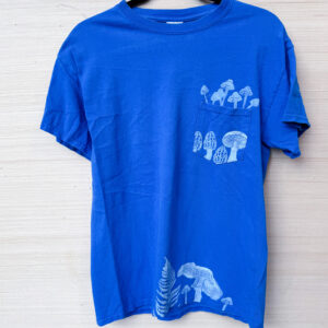 royal blue tee with a pocket on the right chest, printed with white mushrooms and ferns in/from the pocket and on the lower hem.