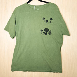 Front of green pocket t-shirt with mushrooms printed growing in and out of the pocket panel.