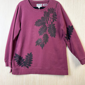 Front of a burgundy sweatshirt with a mountain ash branch printed in black ink growing down from the left shoulder, two small branches growing from the lower right hem, and one small branch on the left sleeve.