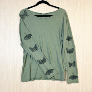 Front of green long sleeve t-shirt with moth and butterfly prints in black ink down each sleeve.