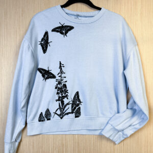 Front of lavender crewneck with fireweed, morel, and swallowtail prints.