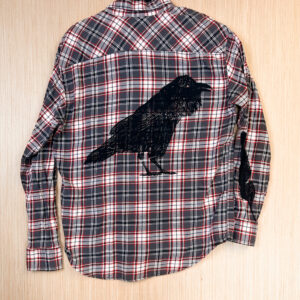 Back of red, white, and grey plaid flannel with raven print.