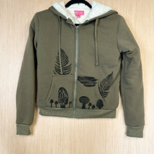 Front of green hooded sweatshirt with fuzzy sherpa lining, pockets printed with black mushrooms and ferns growing out of pocket and from seams.