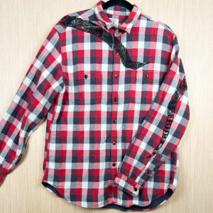 Front of red, grey, and white checked button up with black snake head printed coming down from right shoulder, folded over left sleeve showing where tail is printed on back.