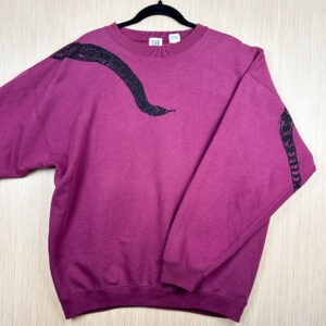 Front of berry-colored sweatshirt with black snake head printed coming down from right shoulder, folded over left sleeve showing where tail is printed on back.