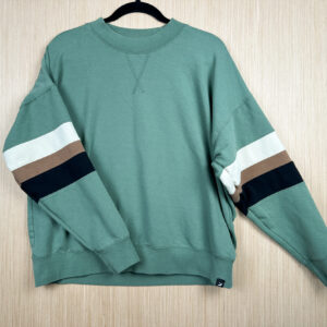 front of green crewneck sweatshirt, with panels in white, tan, and black sewn in stripes on each sleeve.