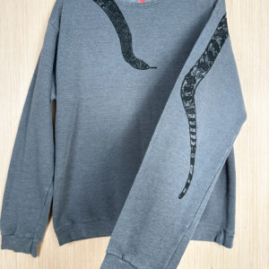 Front of grey sweatshirt with black snake head printed coming down from right shoulder, folded over left sleeve showing where tail is printed on back.