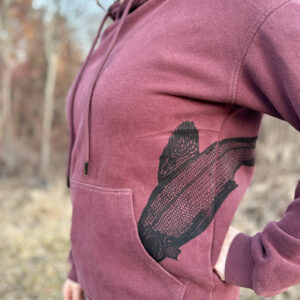 Side view of black arctic grayling print diving into hoodie pocket.