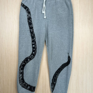 Grey sweats with black snake print with tail at right hip, body looping to bottom edge of right leg, top third and head angled from inseam of left leg, printed up the leg.