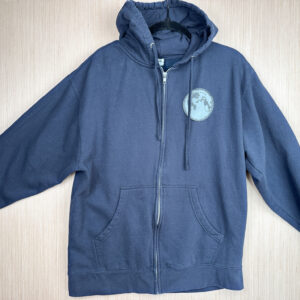 Front of navy blue zip hoodie with black denim patch on left breast with a moon print.