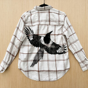 Back of white/brown plaid flannel with life-size black-billed magpie printed at an angle across back panel.