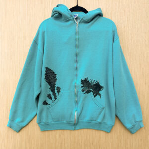 Front of blue zip hoodie with a black ink pika printed popping out of left pocket, beargrass and three indian paintbrush coming out of right pocket.